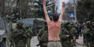 Sin bandera. Un ucraniano protesta frente a soldados rusos en Balaklava. Foto: AP.