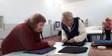 Las voluntarias de cáritas confeccionan acolchados para donar a familias vulnerables.