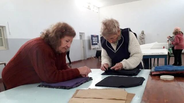 Las voluntarias de cáritas confeccionan acolchados para donar a familias vulnerables.