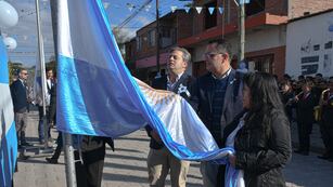 Los concejales Gastón Millón y Lisandro Aguiar y la presidente del Centro Vecinal "9 de Julio", Carmen Martínez, en la ceremonia de izar la Bandera Nacional.