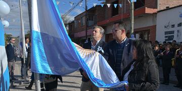Los concejales Gastón Millón y Lisandro Aguiar y la presidente del Centro Vecinal "9 de Julio", Carmen Martínez, en la ceremonia de izar la Bandera Nacional.
