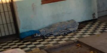 La mujer duerme y hace sus necesidades en la vereda de su casa.