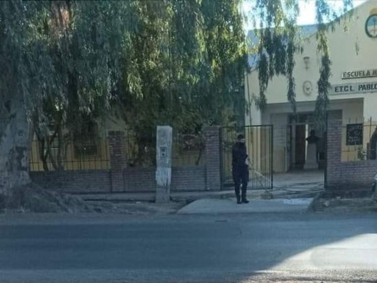 El uniformado fue captado por la cámara limpiando la vereda con una manguera.
