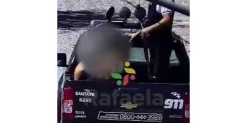 La Policía llevando a uno de los detenidos