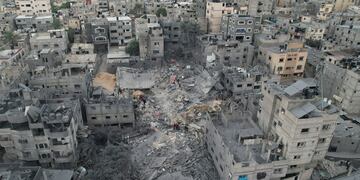 Palestinos inspeccionan los escombros de una vivienda que fue alcanzada por un bombardeo aéreo israelí, en el campo de refugiados de Khan Younis, en la Franja de Gaza, el 27 de octubre de 2023. (AP Foto/Hatem Moussa)