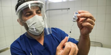 Coronavirus. Un trabajador de la salud prepara una inyección de la vacuna rusa Sputnik V contra el coronavirus en un hospital de Rosario. (DPA)