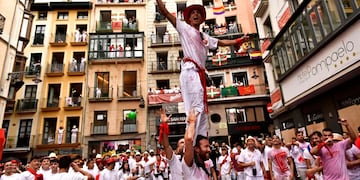 Los juerguistas celebran mientras esperan el lanzamiento del cohete 'Chupinazo', para marcar la apertura oficial de las fiestas de San Fermín 2022 (AP)