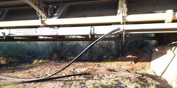 El caño galvanizado dañado y los cables que se intentaron robar bajo el puente de Palmira. Los Andes