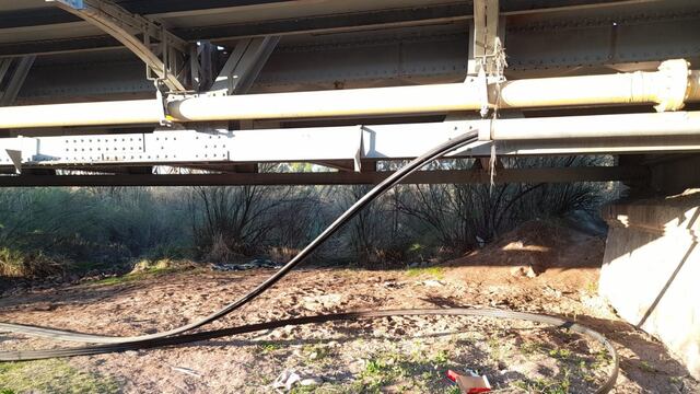 El caño galvanizado dañado y los cables que se intentaron robar bajo el puente de Palmira. Los Andes