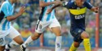 Boca Juniors' forward Carlos Tevez (R) controls the ball past Racing Club's midfielders Oscar Romero (L) and Diego Gonzalez during their Argentina First Division football match at La Bombonera stadium, in Buenos Aires, on December 4, 2016. / AFP PHOTO / A