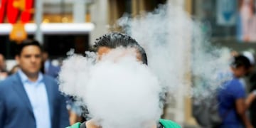 FILE PHOTO: A man uses a vape as he walks on Broadway in New York City, U\u002ES\u002E, September 9, 2019\u002E REUTERS/Andrew Kelly/File Photo