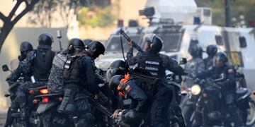 TOPSHOT - An anti-government protester is detained by security forces during clashes with security forces in Caracas on the commemoration of May Day on May 1, 2019, after a day of violent clashes on the streets of the capital spurred by Venezuela's opposition leader Juan Guaido's call on the military to rise up against President Nicolas Maduro\u002E - Guaido called for a massive May Day protest to increase the pressure on Venezuelan President Nicolas Maduro\u002E (Photo by Federico PARRA / AFP)