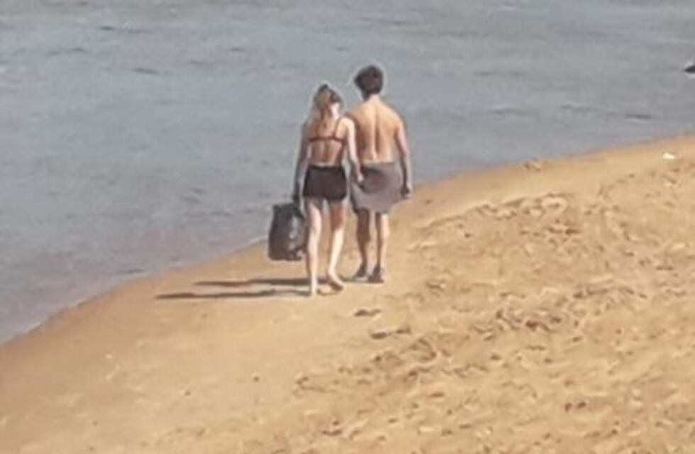 Jóvenes ecologistas: una pareja recolecta basura en la playa