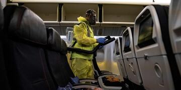 (FILES) In this file photo taken on May 14, 2020 a member of Charles de Gaulle airport personnel nebulizes the interior of an Air France aircraft as part of a disinfection process for airplane, in Terminal 2 of Charles de Gaulle international airport in Roissy near Paris, as France started to ease lockdown measures taken to curb the spread of the COVID-19 (the novel coronavirus)\u002E - After an unprecedented shock to their business, the air transport will need anti-Covid-19 measures, which are the \