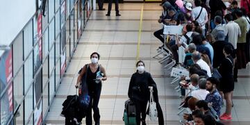 AME3612\u002E SANTIAGO (CHILE), 11/03/2020\u002E- Pasajeros son vistos usando mascarillas para evitar la propagación y el contagio del coronavirus este miércoles, en el aeropuerto Arturo Merino Benítez, en Santiago (Chile)\u002E El Ministerio de Salud de Chile determinó desde ayer establecer una cuarentena obligatoria de 14 días para todo viajero que ingrese al país y haya estado previamente en España o Italia, dos de las naciones europeas más afectadas por el coronavirus\u002E En Chile, donde el primer caso de coronavirus se detectó hace una semana, los casos positivos alcanzan 17, sin ningún muerto ni casos de gravedad por ahora\u002E EFE/Alberto Valdes