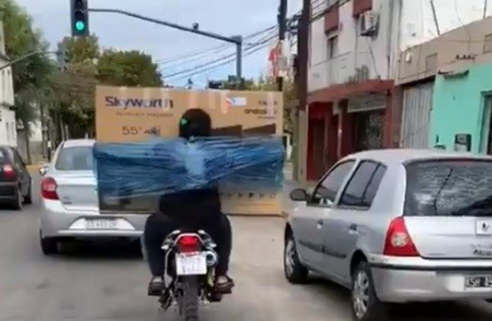 Sin control: transportan en moto un televisor "embalado" al cuerpo y hasta un lavarropas