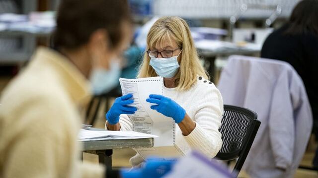 An election judge wearing a protective mask prepares mail-in ballots to be scanned by the Montgomery County Board of Elections at a recreation center in Germantown, Maryland, U\u002ES\u002E, on Tuesday, Oct\u002E 20, 2020\u002E Amid fears of the coronavirus, a record number of voters plan to cast their ballots for the presidential election by mail\u002E Photographer: Al Drago/Bloomberg