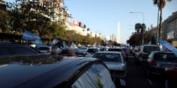 A demonstrator hits a pot lid with a spoon inside a car as she takes part in a protest against Argentina's national government amid the coronavirus disease (COVID-19) outbreak, at the Buenos Aires obelisk, Argentina September 13, 2020\u002E REUTERS/Agustin Marcarian