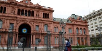 A woman wearing a face mask as a preventive measure against the coronavirus disease (COVID-19), walks in front the Casa Rosada Presidential Palace, in Buenos Aires, Argentina May 21, 2020\u002E REUTERS/Agustin Marcarian