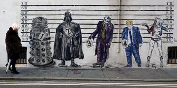 A woman walks past a graffiti mural that depicts Britain's Prime Minister Boris Johnson alongside fictional characters of a Dalek, Darth Vader, The Joker and Harley Quinn set against a line-up in Worthing, Britain January 25, 2020\u002E REUTERS/Russell Boyce