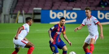 Barcelona's Argentine forward Lionel Messi (C) runs for the ball next to Sevilla's Brazilian midfielder Fernando (L) and Sevilla's Dutch forward Luuk De Jong during the Spanish League football match between FC Barcelona and Sevilla FC at the Camp Nou stadium in Barcelona on October 4, 2020\u002E (Photo by LLUIS GENE / AFP)