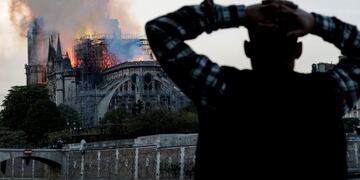 TOPSHOT - Smoke billows as flames destroy the roof of the landmark Notre-Dame Cathedral in central Paris on April 15, 2019\u002E - A major fire broke out at the landmark Notre-Dame Cathedral in central Paris sending flames and huge clouds of grey smoke billowing into the sky, the fire service said\u002E The flames and smoke plumed from the spire and roof of the gothic cathedral, visited by millions of people a year, where renovations are currently underway\u002E (Photo by FRANCOIS GUILLOT / AFP)