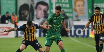 Josu00e9 Luis Fernu00e1ndez disputa la pelota con Patricio Vidal en el partido entre Sarmiento y Rosario Central.