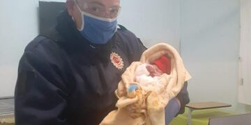 Efectivo policial junto al bebé recién nacido en Capilla del monte\u002E (Foto: gentileza La Estafeta Online)\u002E