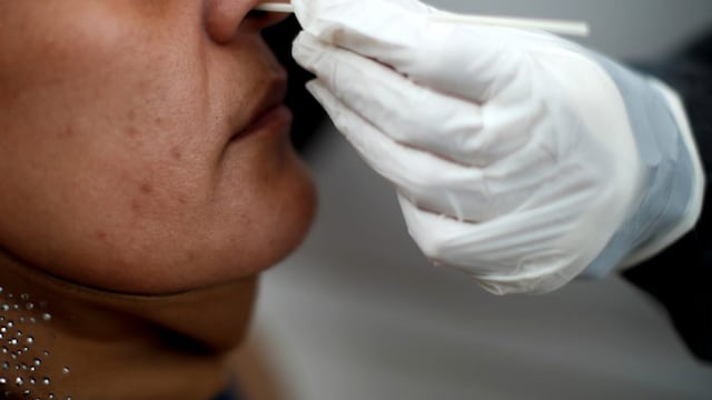 A healthcare worker conducts a nasal swab test for COVID-19 from inside a freestanding coronavirus testing isolation booth at a hospital in Buenos Aires, Argentina,  Monday, Oct\u002E 19, 2020\u002E (AP Photo/Natacha Pisarenko)HOSPITAL POSADAS - PROVINCIA DE BUENOS AIRES - HISOPADO HISOPADOS CASOS DEL DIA  TESTEO TESTEOS