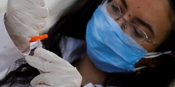 A pharmacist doctor works on the basics of the raw materials for investigational of the coronavirus disease (COVID-19) treatment drug \