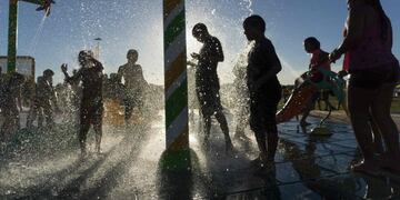 People sunbathe and cool off in the water at an artificial urban beach in Buenos Aires, on January 28, 2017. rnAs temperatures soar over 30c during the summer, portenos - as the residents of Buenos Aires are known - look for relief at artificial beaches o