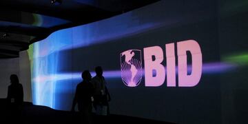 FILE PHOTO: Visitors walk past a screen with the logo of Banco Interamericano de Desarrollo (BID), also known as the Inter-American Development Bank, at the Atlapa Convention Center in Panama City March 13, 2013\u002E REUTERS/Carlos Jasso/File Photo