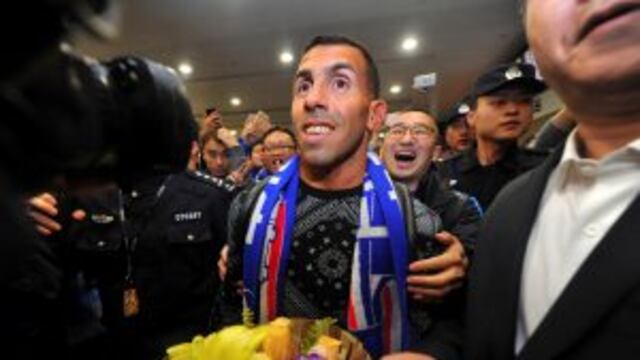 Argentine striker Carlos Tevez, center, arrives to fans and media at the Pudong International Airport in Shanghai on Thursday, Jan. 19, 2017. Shanghai Shenhua has recruited Tevez and has reportedly made the Argentine the highest-paid soccer player in the