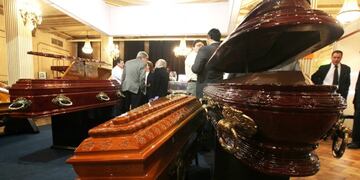 ((((ACOMPAÑA CRÓNICA: ARGENTINA - FÚNEBRE)))) BAS03 - BUENOS AIRES (ARGENTINA) 09/09/2010\u002E Detalle de varias personas conversando junto a varios féretros hoy, jueves 9 de septiembre de 2010, durante la Funexpo 2010, espacio de debate para decenas de empresarios de un sector que el común de las personas prefiere ver de lejos, por la sensibilidad de un tema tabú como la muerte\u002E Urnas de sal para arrojar al mar las cenizas de los muertos y un servicio de e-mail para enviar mensajes a los seres queridos una vez que nos llegue la hora son algunos de los novedosos servicios presentados estos días en la exposición del sector\u002EEFE/Cézaro De Luca buenos aires feretros cajones de muertos Funexpo 2010