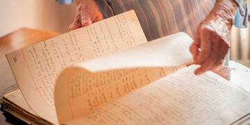 Esther Juana mostrando el viejo cuaderno de actas\u002E