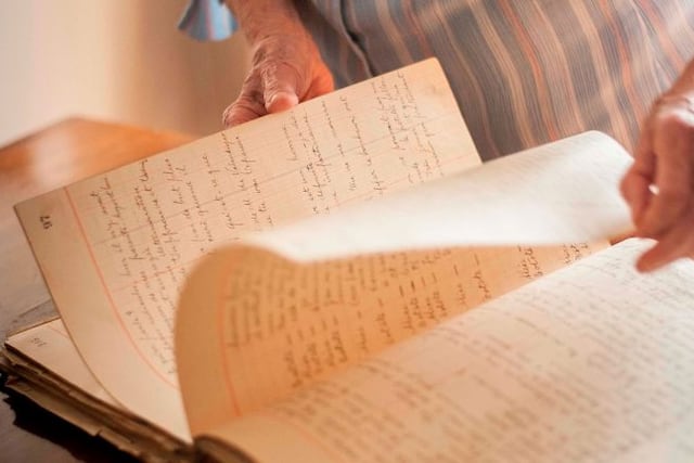 Esther Juana mostrando el viejo cuaderno de actas\u002E