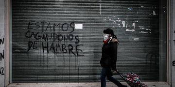 AME8393\u002E BUENOS AIRES (ARGENTINA), 23/06/2020\u002E- Personas transitan frente a un local cerrado a causa de la crisis económica hoy, martes en la Ciudad de Buenos Aires\u002E coronavirus\u002E EFE/Juan Ignacio Roncoroni   negocio negocios comercios comercio locales cerrados estamos cagandonos de hambre persiana baja