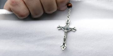 A Christian fundamentalist holds a crucifix during a protest against the play \