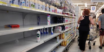 Shoppers browse near-empty shelves at a supermarket in Buenos Aires, as people hoard cleaning products due to the coronavirus outbreak, in Buenos Aires, Argentina March 13, 2020\u002E REUTERS/Agustin Marcarian
