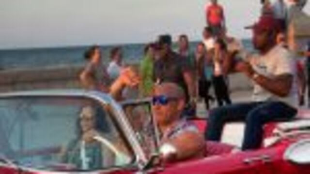 Actor Vin Diesel drives a vintage American car next to actress Michelle Rodriguez and another unidentified person in the back seat, after a session of filming of the latest installment of the