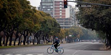 A man crosses an avenue on his bicycle in Buenos Aires on July 18, 2020 a day after Argentina's government announced it was relaxing coronavirus containment measures in the capital to fight the COVID-19 pandemic\u002E - From Monday, non-essential businesses, industry and certain professional activities can restart and citizens will also be allowed to go outside for sport and to visit places of worship\u002E (Photo by Alejandro PAGNI / AFP)