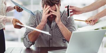 Hombre abrumado por mucho trabajo.