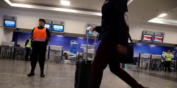 A policewoman stands in front of closed counters of Argentina's flagship air carrier Aerolineas Argentinas as a passanger walks by at Buenos Aires airport, Argentina October 31, 2017\u002E REUTERS/Marcos Brindicci