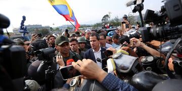 ADDS IDENTIFICATION OF SOLDIER - Venezuela's opposition leader and self-proclaimed president Juan Guaido, center, stands with National Guard Lieutenant Colonel Ilich Sanchez, who is helping to lead a military uprising, center left, as they talk to the press and supporters outside La Carlota air base in Caracas, Venezuela, Tuesday, April 30, 2019\u002E Guaidó took to the streets with activist Leopoldo Lopez and a small contingent of heavily armed troops early Tuesday in a bold and risky call for the military to rise up and oust Maduro\u002E (AP Photo/Fernando Llano)
