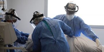 Doctors, dressed in full protective gear, attend to a patient in an intensive care unit designated for people infected with COVID-19, at the Posadas hospital in Buenos Aires, Argentina, Thursday, Sept\u002E 17, 2020, amid the new coronavirus pandemic\u002E (AP Photo/Natacha Pisarenko) terapia intensiva casos del dia hospital posadas