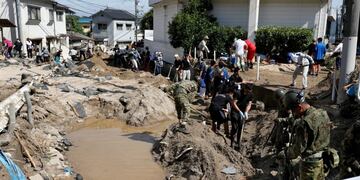 Personas caminan por una zona afectada por las lluvias en Kurashiki\u002E