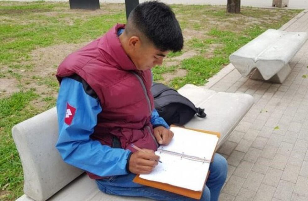 El joven de la foto estudiando en el Parque es el abanderado de su colegio