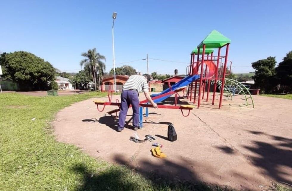 Un abuelo y su nieta reparan los juegos de una plaza de Iguazú