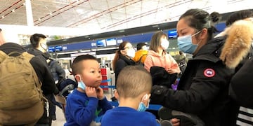 FILE - In this Saturday, Jan\u002E 25, 2020, file photo, children adjust their face masks as they wait in line at check-in counters at Beijing Capital International Airport in Beijing\u002E British Airways and Asian budget carriers Lion Air and Seoul Air are suspending all flights to China as fears spread about the outbreak of a new virus that has killed more than 130 people\u002E British Airways said Wednesday, Jan\u002E 29, 2020, it is immediately suspending all flights to and from mainland China after the U\u002EK\u002E government warned against unnecessary travel to the country\u002E (AP Photo/Yanan Wang, File)