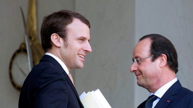 (FILES) This file photo taken on March 26, 2014 shows France's president Francois Hollande (R) speaking with Elysee palace's deputy secretary-general Emmanuel Macron in Paris. nMacron is the clear favourite to become France's youngest-ever president afte